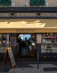 Fachada de la pastelería y confitería Miremont en Biarritz, Francia, con toldo amarillo y escaparate de productos dulces