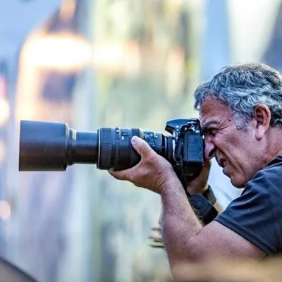 inaki-penalba Iñaki Peñalba tomando una foto con cámara profesional y lente largo en exteriores