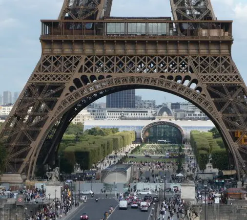 torre-eiffel-primer-piso-paris Parte inferior de la Torre Eiffel de Paris con cientos de personas visitándola.